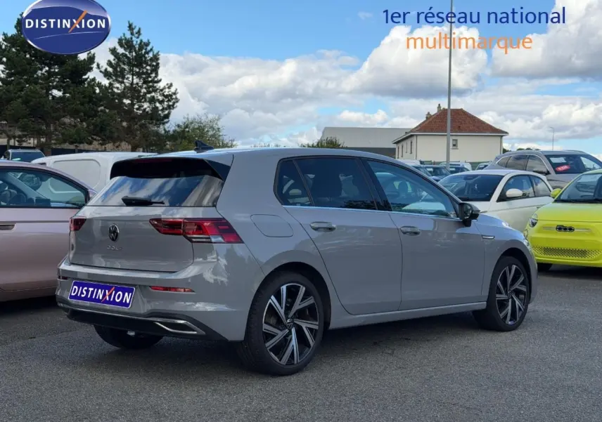 Volkswagen Golf 1.5 TSI gris lunaire vue 3/4 arrière droit, jantes alliage et feux arrière LED visibles.