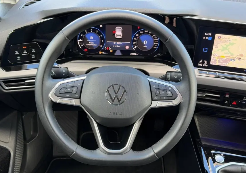 Vue rapprochée du volant cuir multifonction et du tableau de bord numérique de la Volkswagen Golf 2024 gris lunaire.