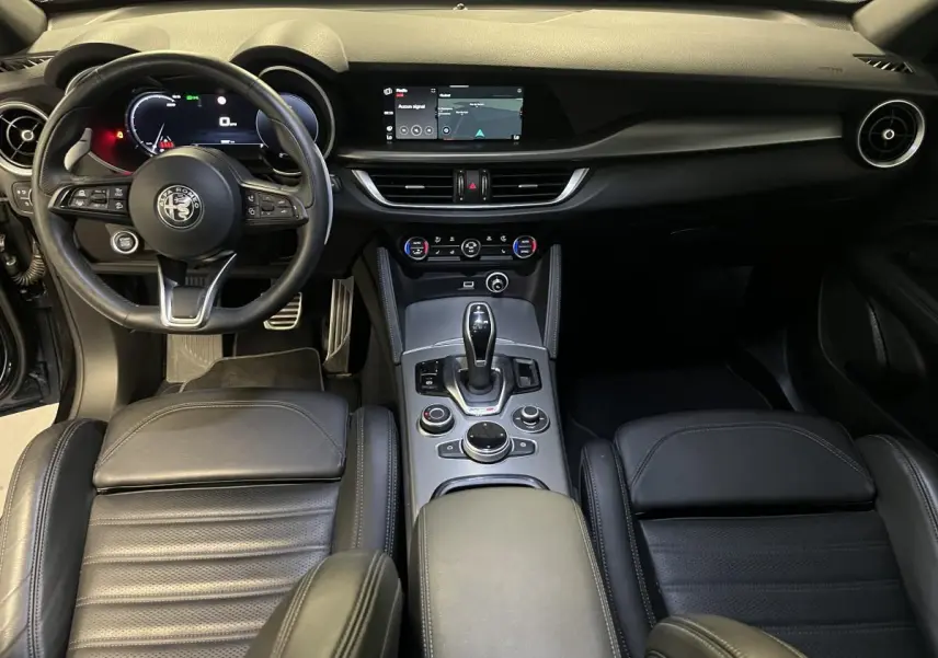 Intérieur noir cuir de l'Alfa Romeo Stelvio Veloce 2024, vue avant sur tableau de bord et console centrale.