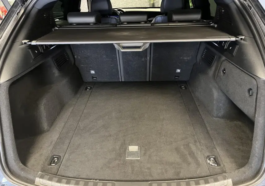 Vue arrière du coffre spacieux et noir de l'Alfa Romeo Stelvio 2.2 D Veloce 2024 avec cache-bagages rétractable.