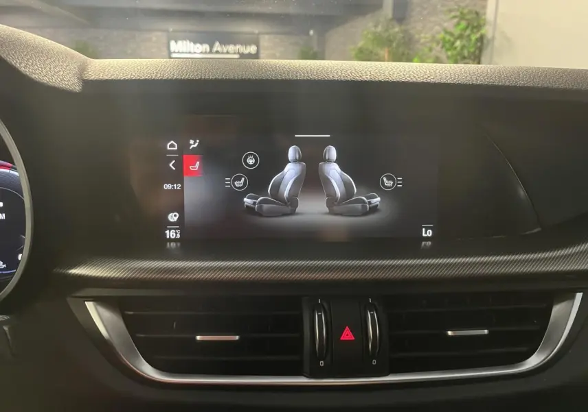 Écran tactile du tableau de bord de l'Alfa Romeo Stelvio 2024 montrant le réglage des sièges chauffants en intérieur noir.