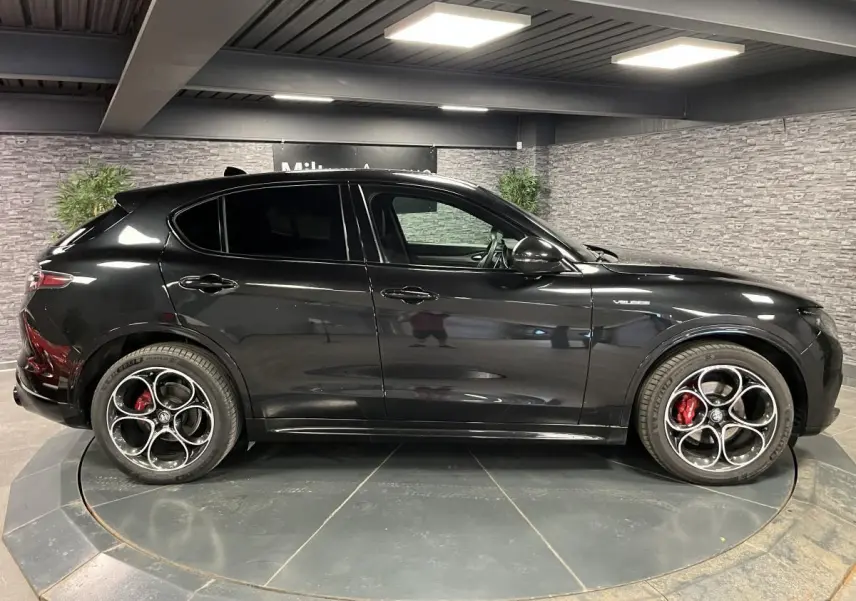 Profil droit de l'Alfa Romeo Stelvio Veloce 2024 noir Vulcano avec jantes 20 pouces et étriers Brembo rouges.
