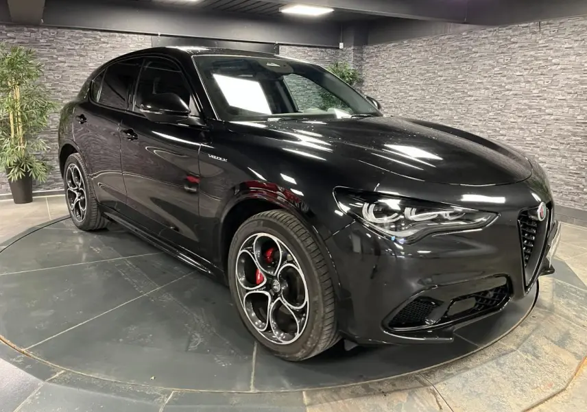 Alfa Romeo Stelvio Veloce noir Vulcano en 3/4 avant droit, avec jantes 20' Competizione et étriers Brembo rouges.