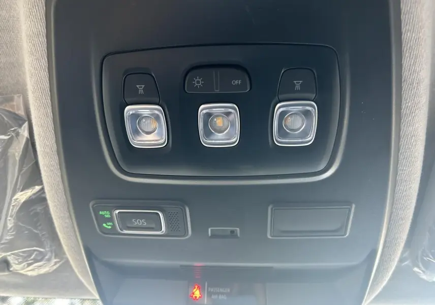 Gros plan sur les commandes de lève-vitres et réglage des rétroviseurs du côté conducteur du Renault Trafic Fourgon Gris Urbain.