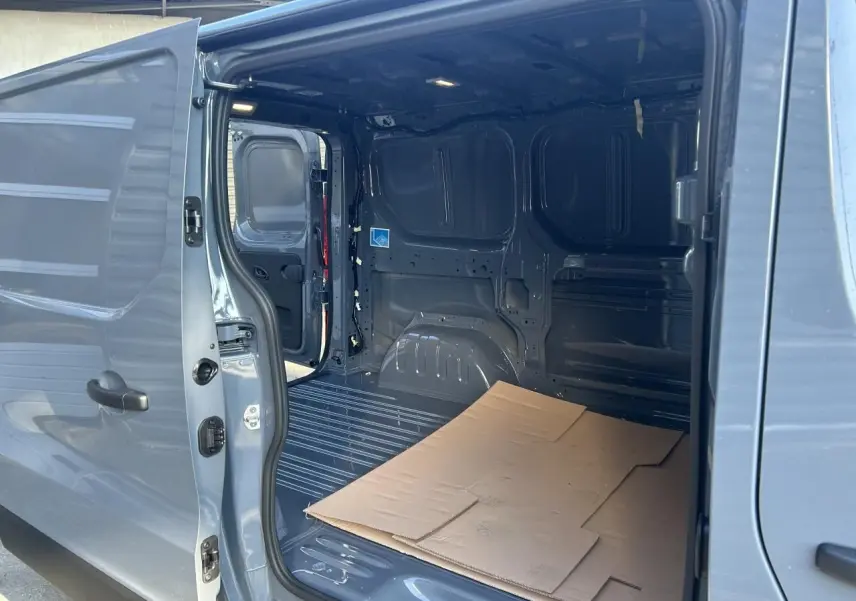 Vue rapprochée du volant gris du Renault Trafic Fourgon 2025, avec commandes intégrées et tableau de bord visible.