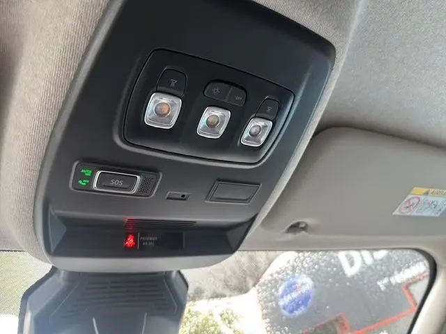 Vue intérieure en gros plan du plafonnier avec commandes d’éclairage et bouton SOS du Renault Trafic Fourgon gris urbain 2025.