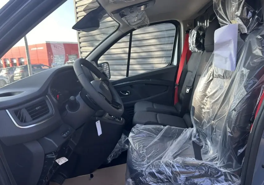 Vue arrière d’un Renault Trafic Fourgon gris urbain 2025, portes battantes fermées avec caméra et radar de recul visibles.