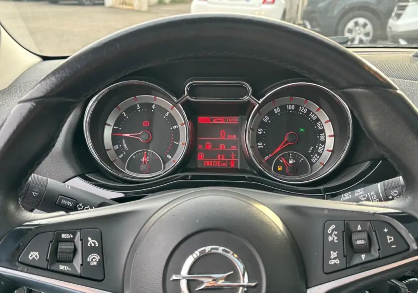 Vue rapprochée du tableau de bord et volant cuir noir d'une Opel Adam 2016 avec commandes multifonctions visibles.
