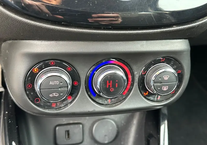 Gros plan sur les commandes de climatisation automatique de l'Opel Adam 2016, avec réglages en rouge et bleu.