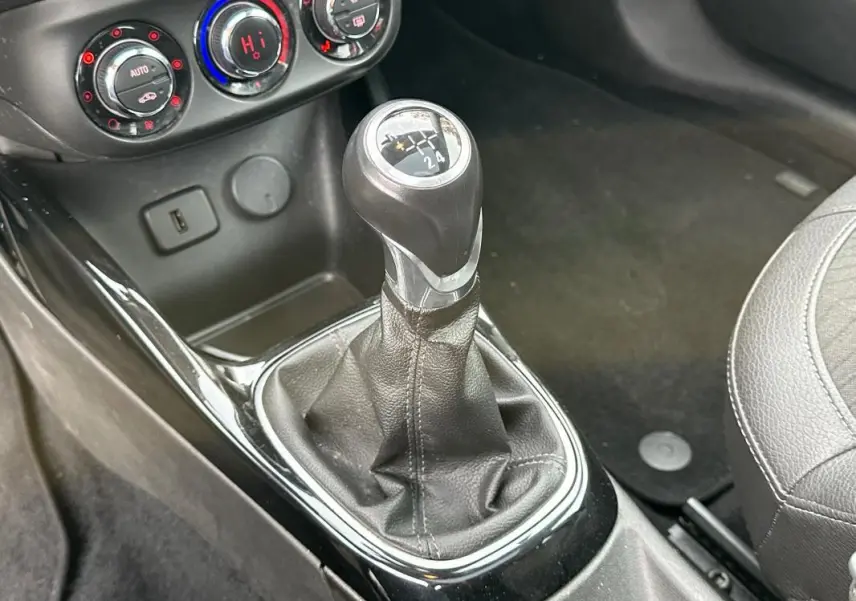 Gros plan sur le levier de vitesse manuel entouré de garnitures noires dans l'habitacle de l'Opel Adam 2016.
