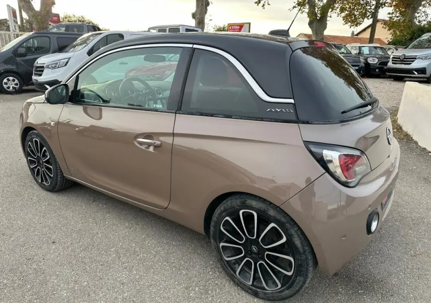 Opel Adam marron vue 3/4 arrière droit avec toit noir, jantes alliage 16 pouces et vitres surteintées.