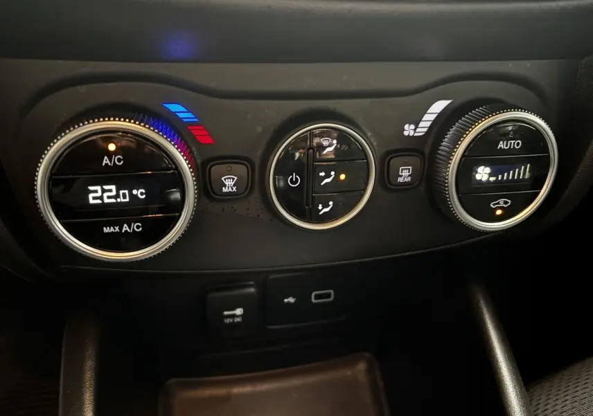 Gros plan sur les commandes de climatisation digitale du tableau de bord noir du Fiat Tipo blanc de 2021.