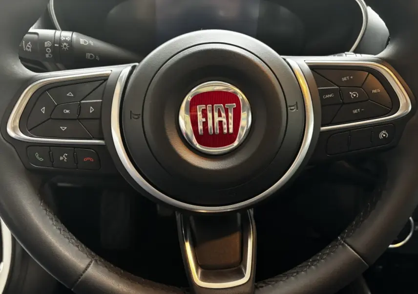 Gros plan sur le volant cuir et alu du Fiat Tipo 1.6 MultiJet 2021 avec commandes multifonctions intégrées.
