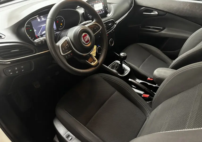 Vue intérieure côté conducteur de la Fiat Tipo 1.6 MultiJet 2021 avec volant cuir, tableau de bord numérique et boîte manuelle.