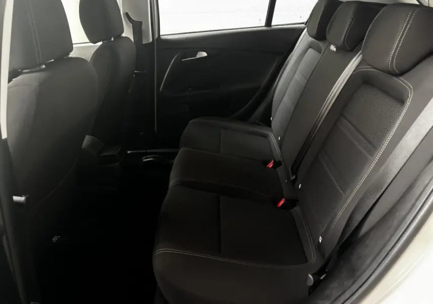 Vue intérieure côté droit des sièges arrière noirs du Fiat Tipo blanc 2021 avec ceintures et appuie-têtes visibles.