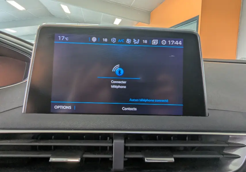 Écran central tactile du tableau de bord du Peugeot 3008 blanc toit noir, affichant la connexion Bluetooth.