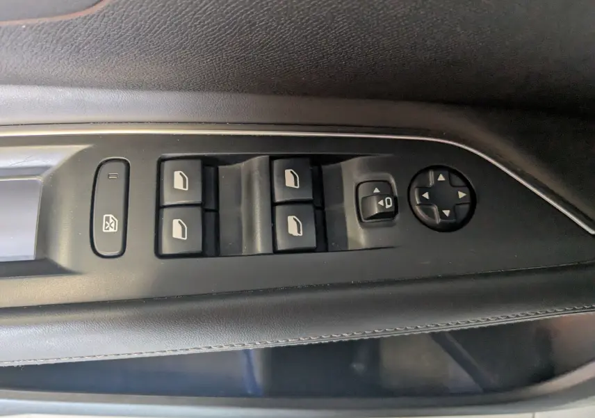 Gros plan sur les commandes des vitres et rétroviseurs côté conducteur du Peugeot 3008 blanc toit noir, version 2018.