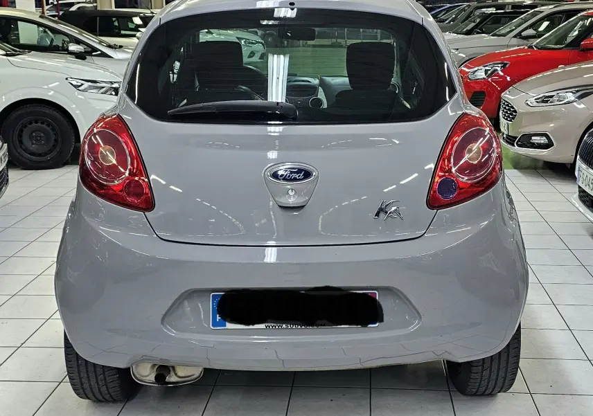 Vue arrière d'une Ford KA+ gris clair de 2016, avec feux rouges arrondis et logo Ford visible au centre.