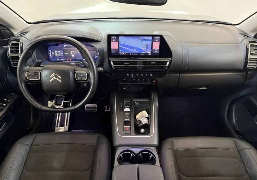 Vue intérieure avant du Citroën C5 Aircross 2023, tableau de bord noir avec écran tactile central et volant cuir multifonctions.