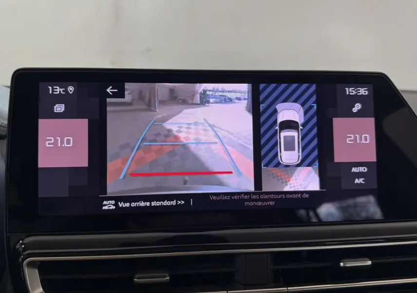 Écran tactile intérieur du Citroën C5 Aircross 2023 montrant la caméra de recul avec guidage et vue aérienne du véhicule gris clair.