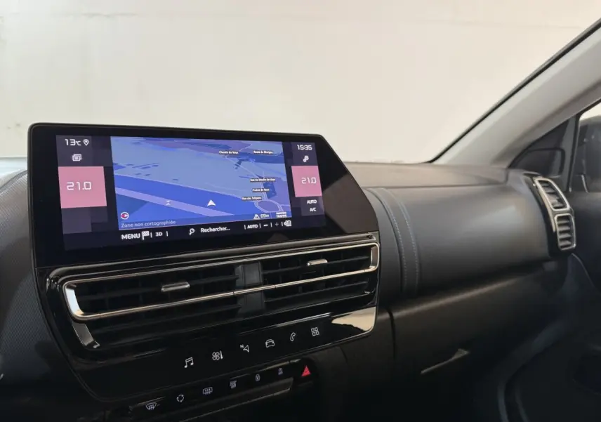 Vue intérieure du tableau de bord du Citroën C5 Aircross gris clair, avec écran tactile central affichant la navigation.