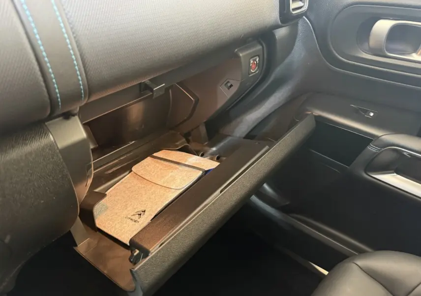 Intérieur de la Citroën C5 Aircross 2023, boîte à gants ouverte avec pochette grise, vue côté passager.
