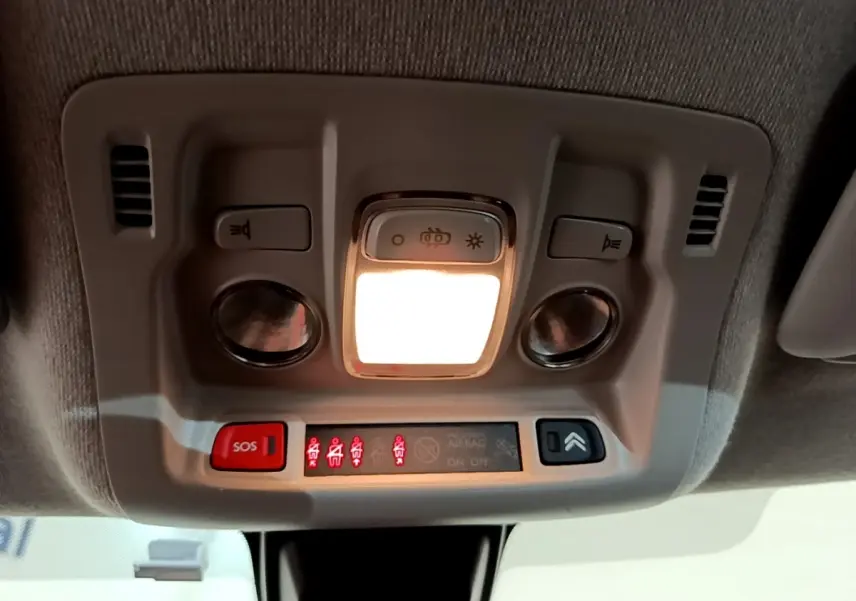 Vue en gros plan du plafonnier intérieur blanc avec éclairage et boutons SOS de la Citroën C3 blanche 2021.