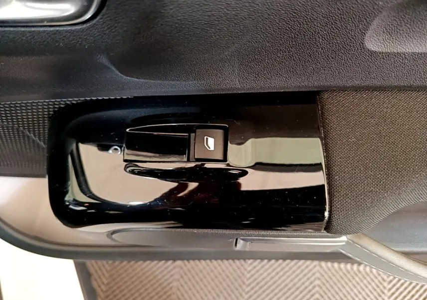 Bouton de commande de lève-vitre électrique sur la porte intérieure côté conducteur d'une Citroën C3 blanche.