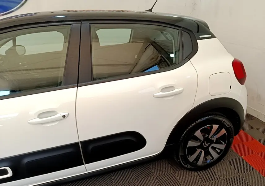 Vue côté droit arrière d'une Citroën C3 blanche avec protections noires et jantes alliage distinctives.