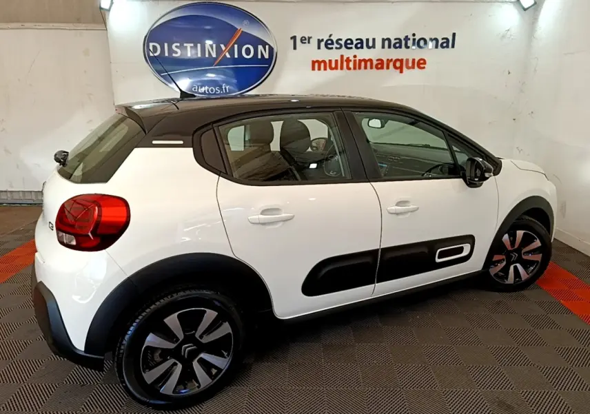 Citroën C3 blanche vue de profil droit, avec toit noir et protections latérales noires caractéristiques.