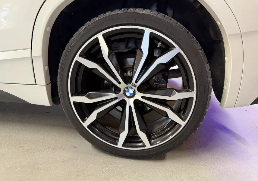 Gros plan sur la jante alu 19'' noire et argentée du côté gauche d’un BMW X2 blanc 2023 sDrive18d.