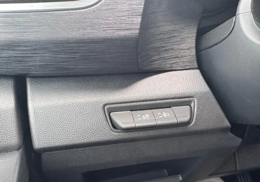 Détail des commandes de réglage des feux et du tableau de bord sur Renault Trafic Fourgon gris foncé, vue intérieure côté conducteur.