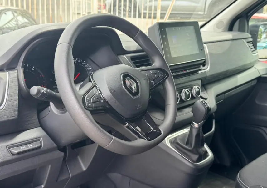 Vue intérieure côté conducteur du Renault Trafic Fourgon 2024, montrant le volant, tableau de bord et écran tactile central.