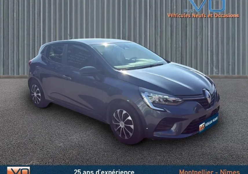 Renault Clio V TCe 90 gris vue 3/4 avant droit sur fond urbain avec jantes noires et grises.