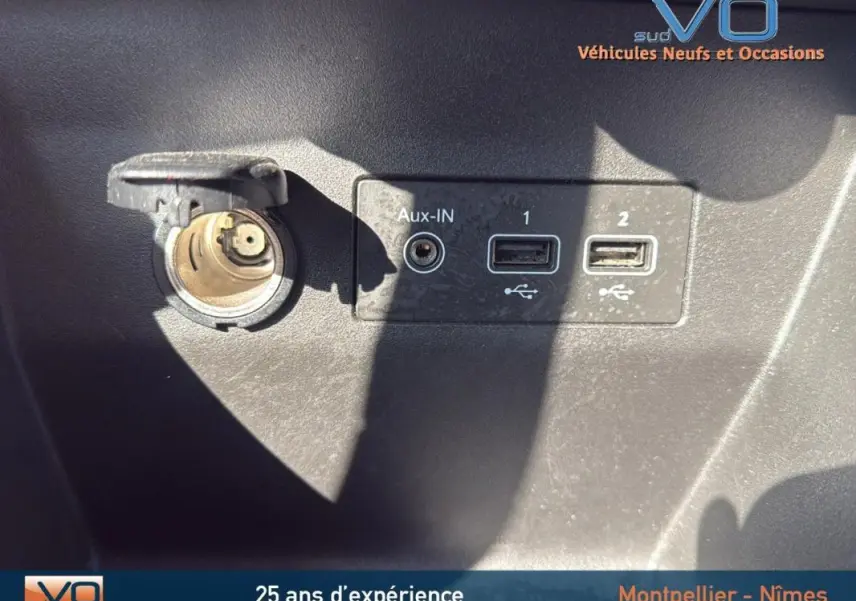 Prise allume-cigare et ports USB avec entrée Aux-IN sur tableau de bord noir d'une Renault Clio gris 2022.