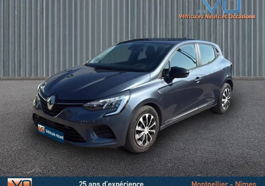 Renault Clio gris 2022 en 3/4 avant droit, avec jantes alliage et calandre distinctive sous un ciel dégagé.