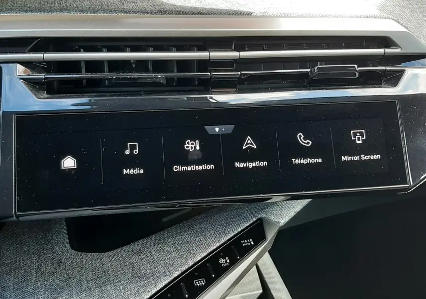 Vue rapprochée de l’écran tactile central et des commandes de climatisation du Peugeot 5008 gris titane 2025.