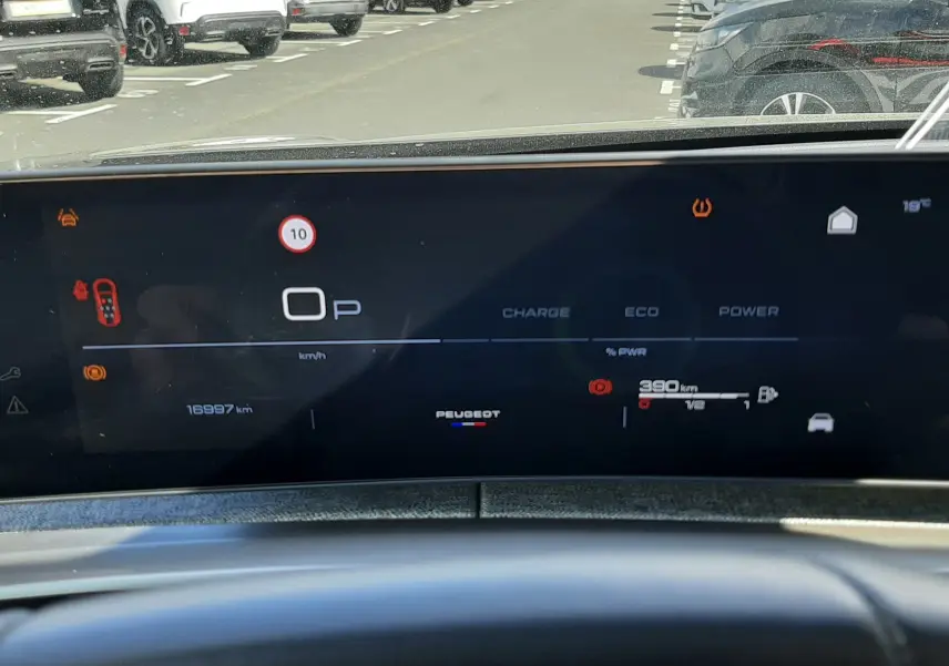 Tableau de bord numérique du Peugeot 5008 Hybrid 145ch, affichage en mode parking avec autonomie et alertes visibles.