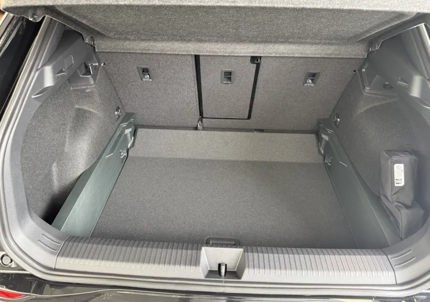 Coffre ouvert vu de dessus du Volkswagen T-Roc noir intense, montrant un espace de rangement propre et bien agencé.
