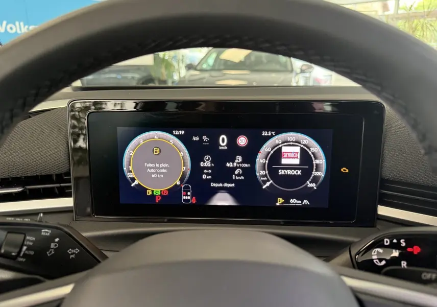 Vue depuis le poste de conduite du tableau de bord numérique du Volkswagen T-Roc noir intense, affichant la vitesse et alertes.