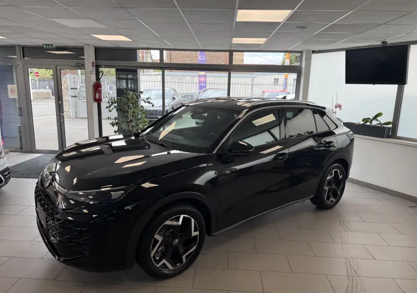 Volkswagen T-Roc R-Line eTSI 150Ch noir intense, vue 3/4 avant droit en intérieur lumineux.