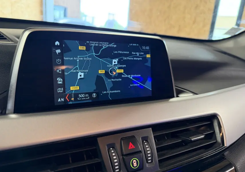 Écran central du système de navigation du BMW X1 noir (F48) 2019, vue intérieure du tableau de bord.