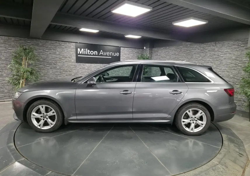 Profil côté gauche d'une Audi A4 Avant gris métallisé 2018 avec jantes alu 17 pouces à cinq branches doubles.