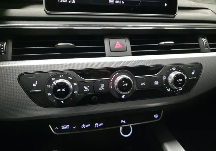 Tableau de bord de l'Audi A4 2018, vue centrée sur la console de climatisation automatique avec réglages et boutons lumineux.