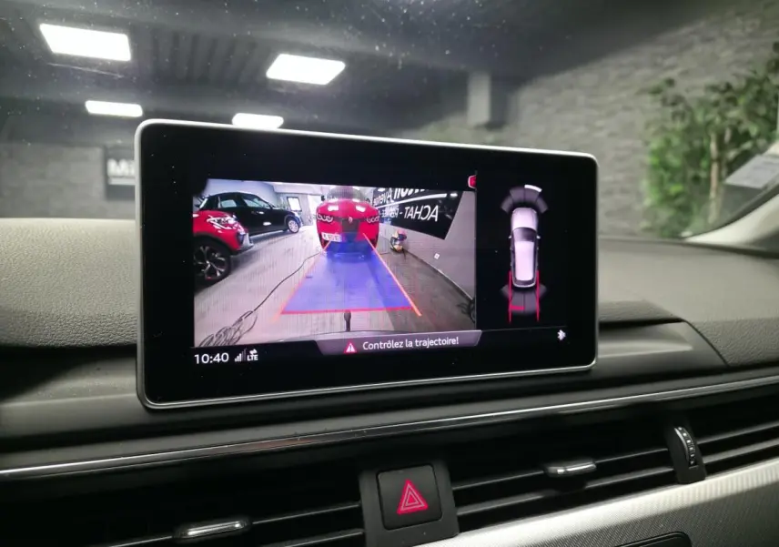 Écran de caméra de recul dans l'habitacle d'une Audi A4 Avant gris, affichant l'aide au stationnement arrière.
