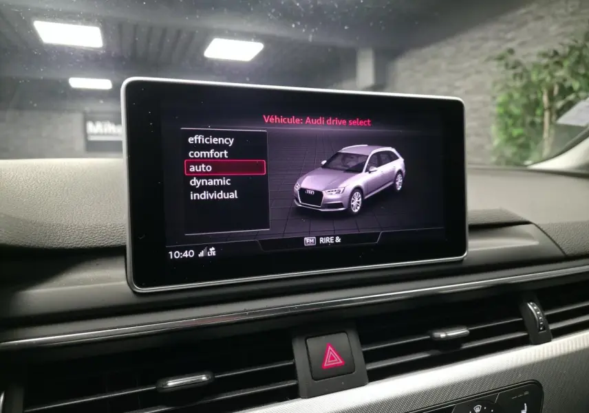 Écran central affichant le mode Audi Drive Select avec une Audi A4 gris métallisé vue de 3/4 avant droit en illustration.