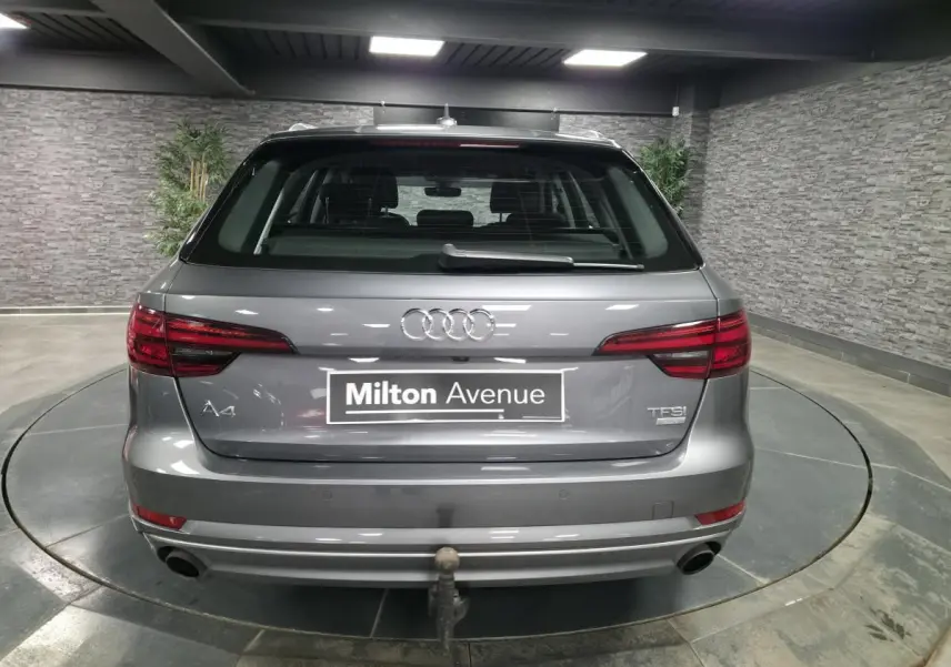 Vue arrière d'une Audi A4 Avant gris métallisé 2018 avec double sortie d'échappement et crochet d'attelage visible.