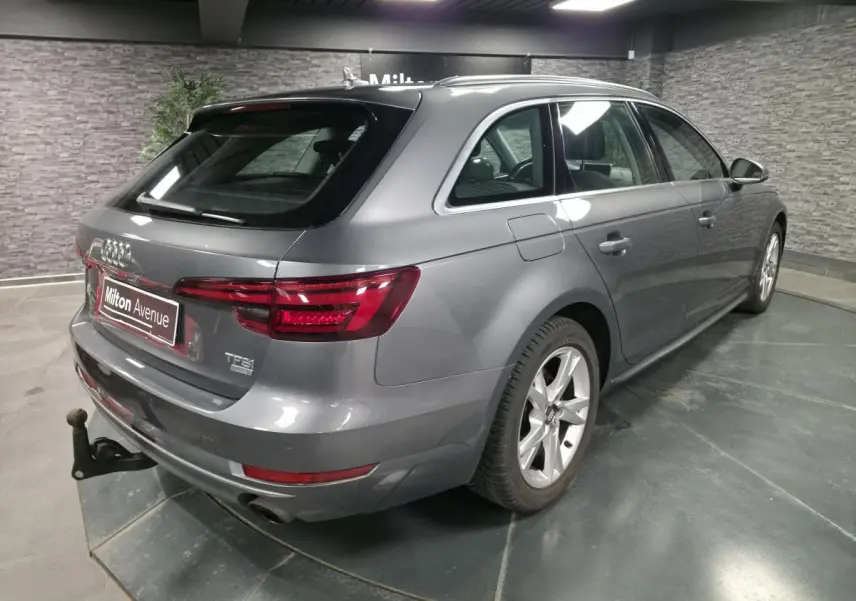 Audi A4 Avant gris métallisé vue 3/4 arrière droit avec jantes alu 17 pouces et crochet d'attelage visible.