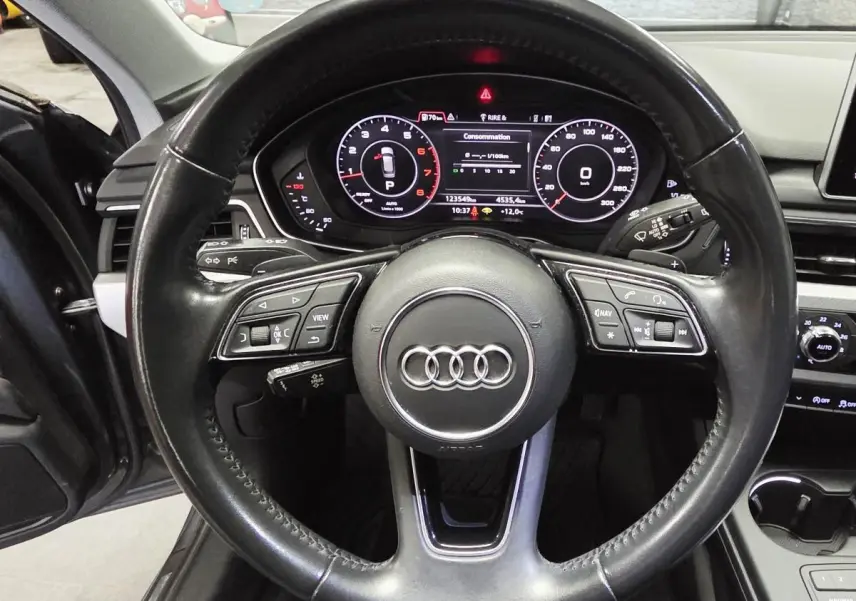 Vue rapprochée du volant cuir multifonction et du tableau de bord numérique de l'Audi A4 Avant gris 2018.