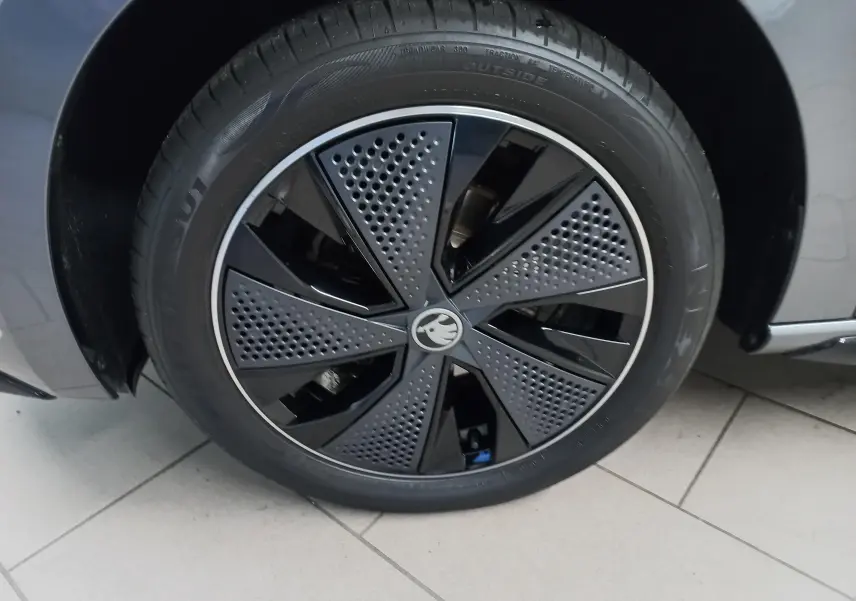 Gros plan sur la roue avant droite de la Skoda Scala 1.5 TSI 150 DSG7 Monte-Carlo gris graphite avec jante noire au design perforé.